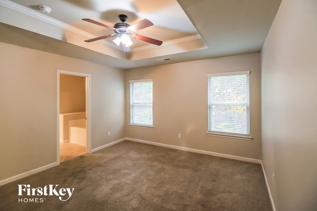 an empty room with a ceiling fan and a closet