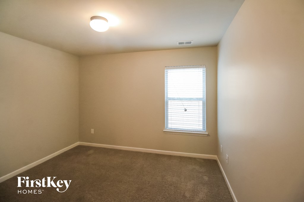 a empty room with a window and a carpet