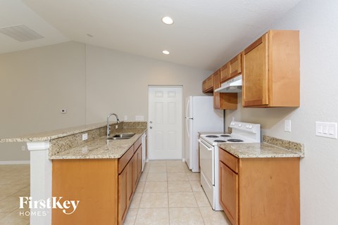a kitchen with white appliances and granite counter tops