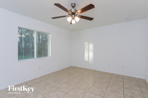 a living room with a ceiling fan and a tiled floor