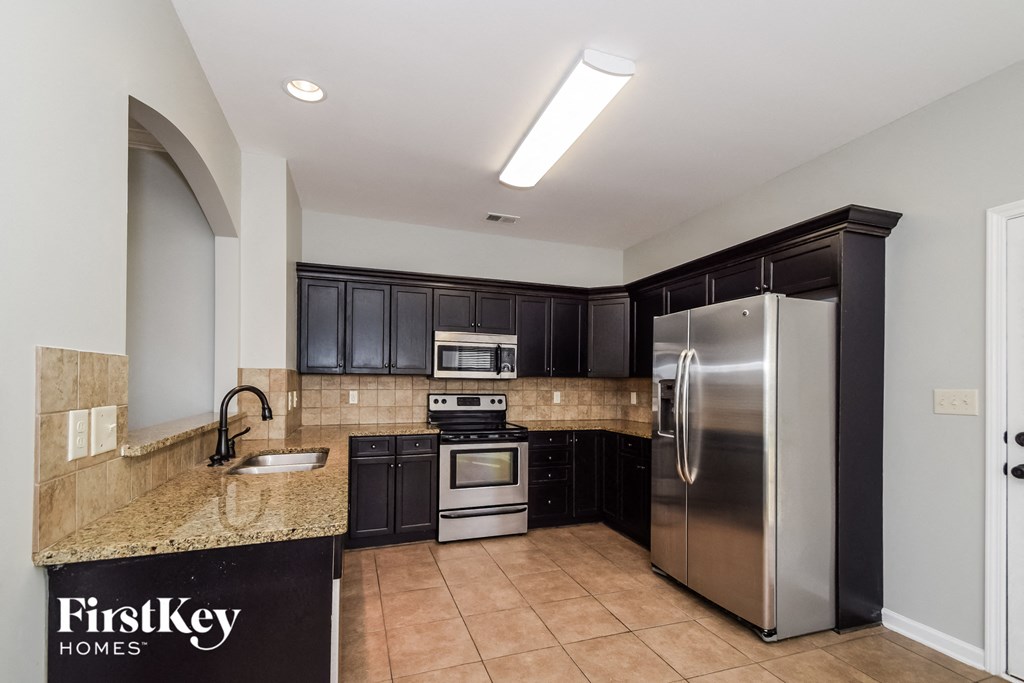 A kitchen with a granite countertop and a refrigerator.