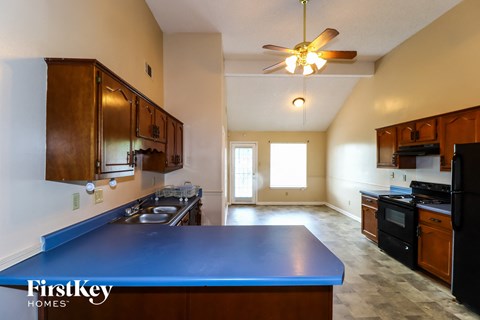 A kitchen with a blue counter top and wooden cabinets.