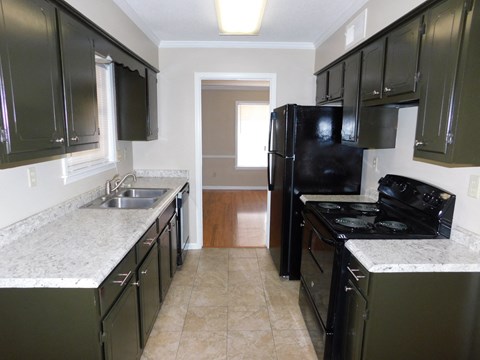 a kitchen with black appliances and white counter tops and black cabinets
