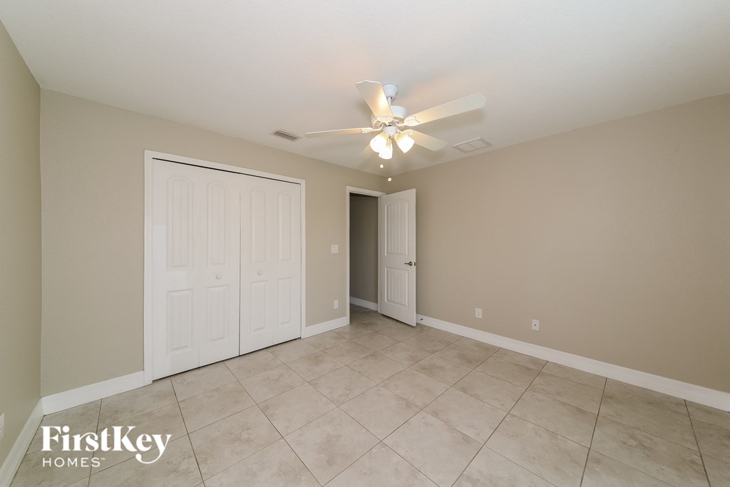the spacious living room has a ceiling fan and tile flooring