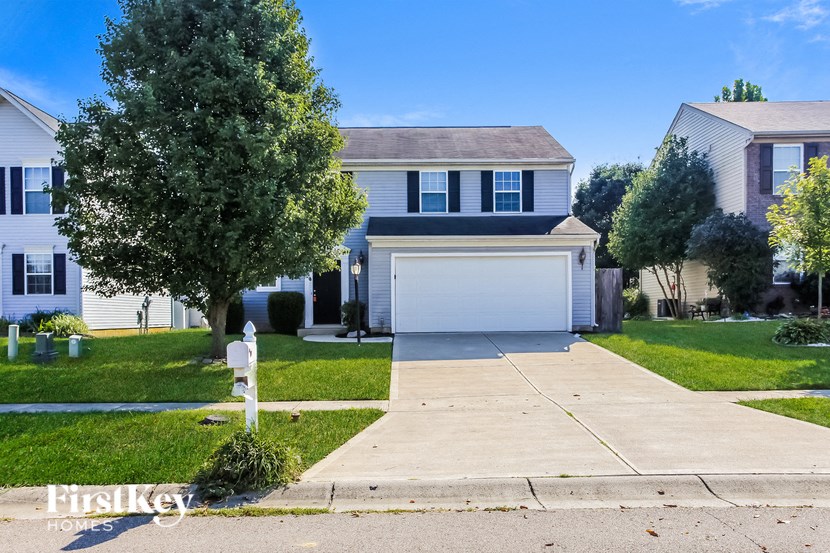 A white house with a garage is for sale by First Key Homes.
