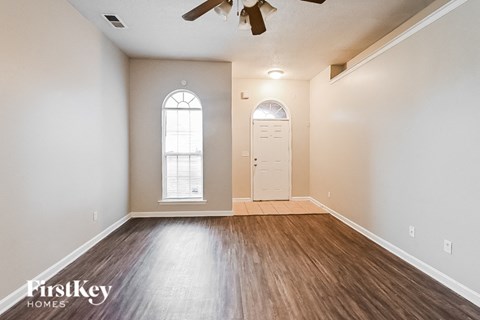 A room with wooden floors and a ceiling fan.