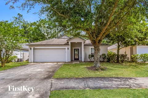 a white house with a tree in front of it