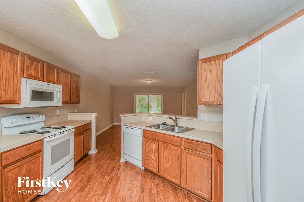a kitchen with white appliances and wooden cabinets