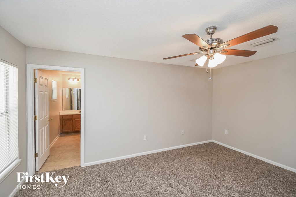 the living room of an empty house with a ceiling fan