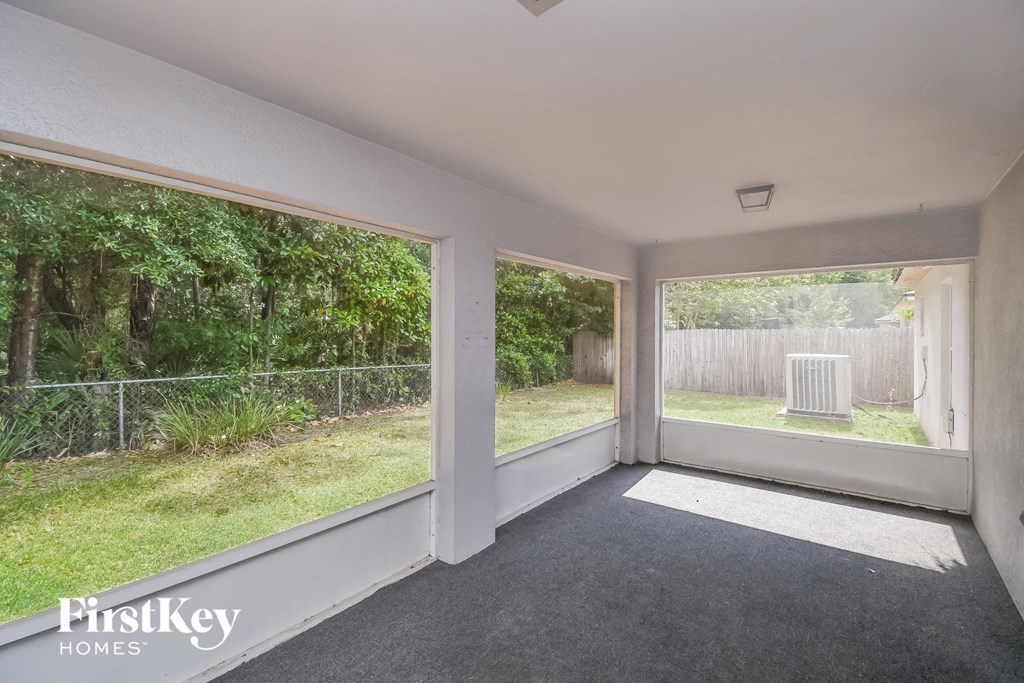 the living room of a house with large windows and a patio
