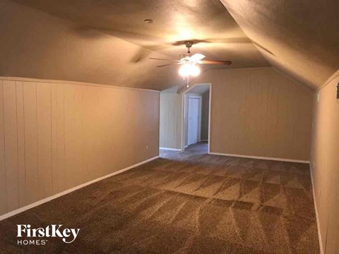 a living room with a ceiling fan and a carpeted floor
