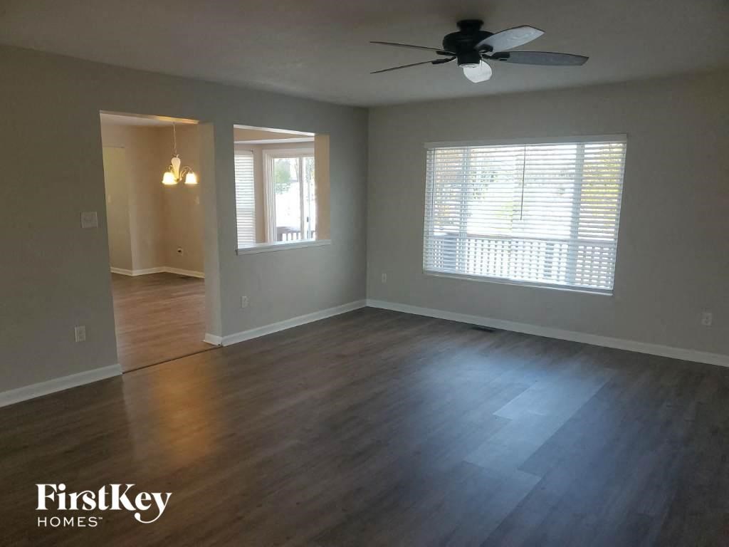 A room with a ceiling fan and a window with blinds.