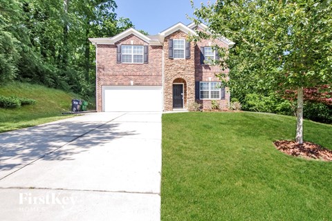 a brick house with a white garage door and a lawn