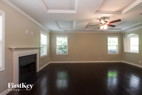 the living room with the fireplace and ceiling fan