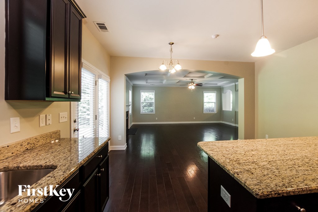 an empty kitchen and living room with a granite counter top
