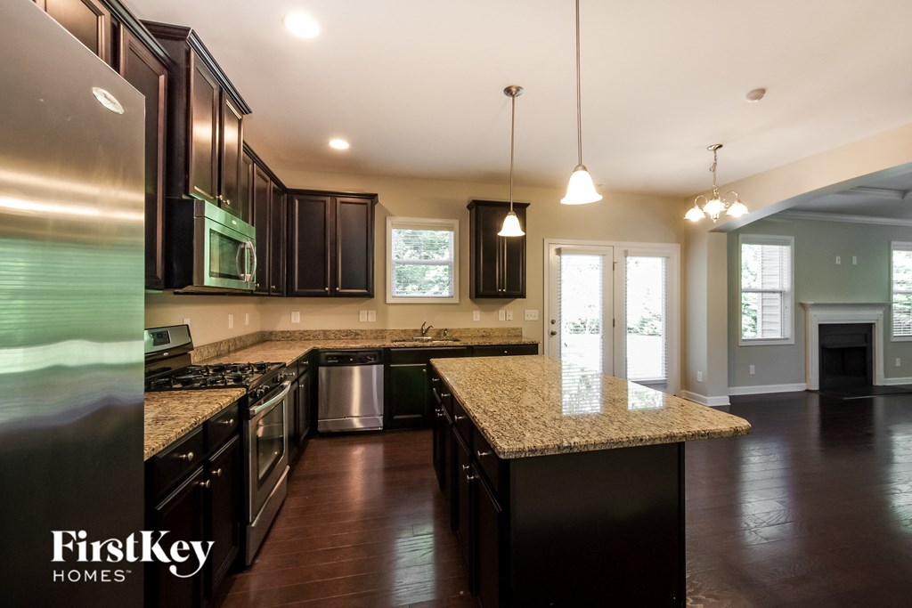 a kitchen with granite counter tops and dark wood cabinets