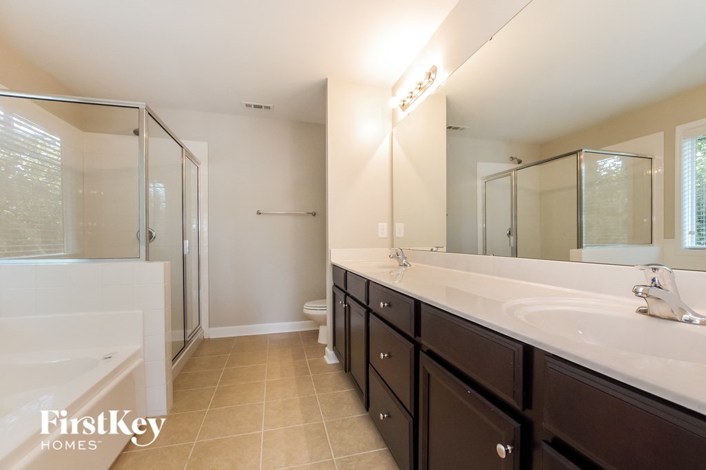 a bathroom with two sinks and a shower and a bath tub