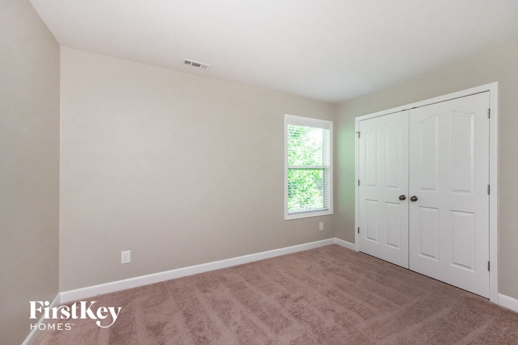 a bedroom with a carpeted floor and two white doors