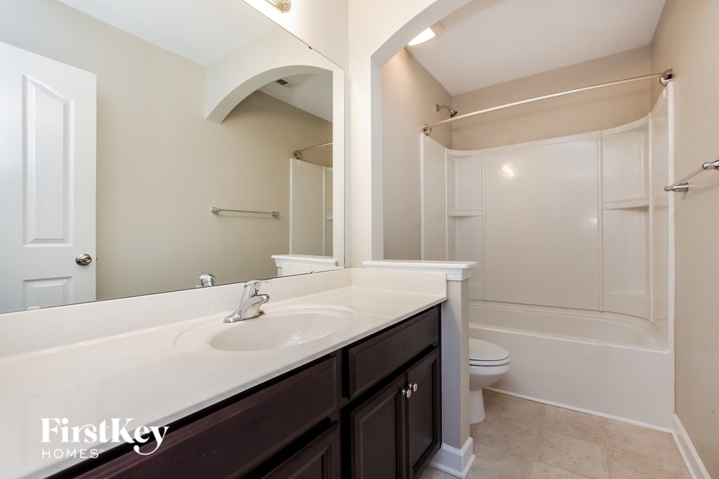 a bathroom with a sink and a shower and a toilet