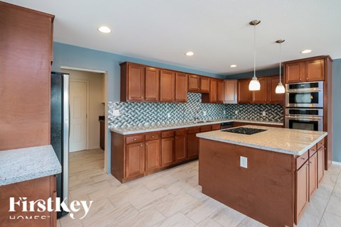 A kitchen with wooden cabinets and a blue backsplash.