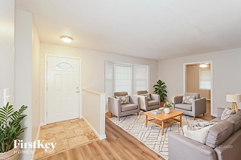 A living room with a couch, chairs, and a coffee table.