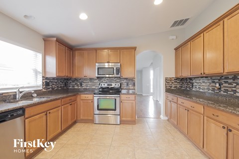 A kitchen with wooden cabinets and a stone countertop.