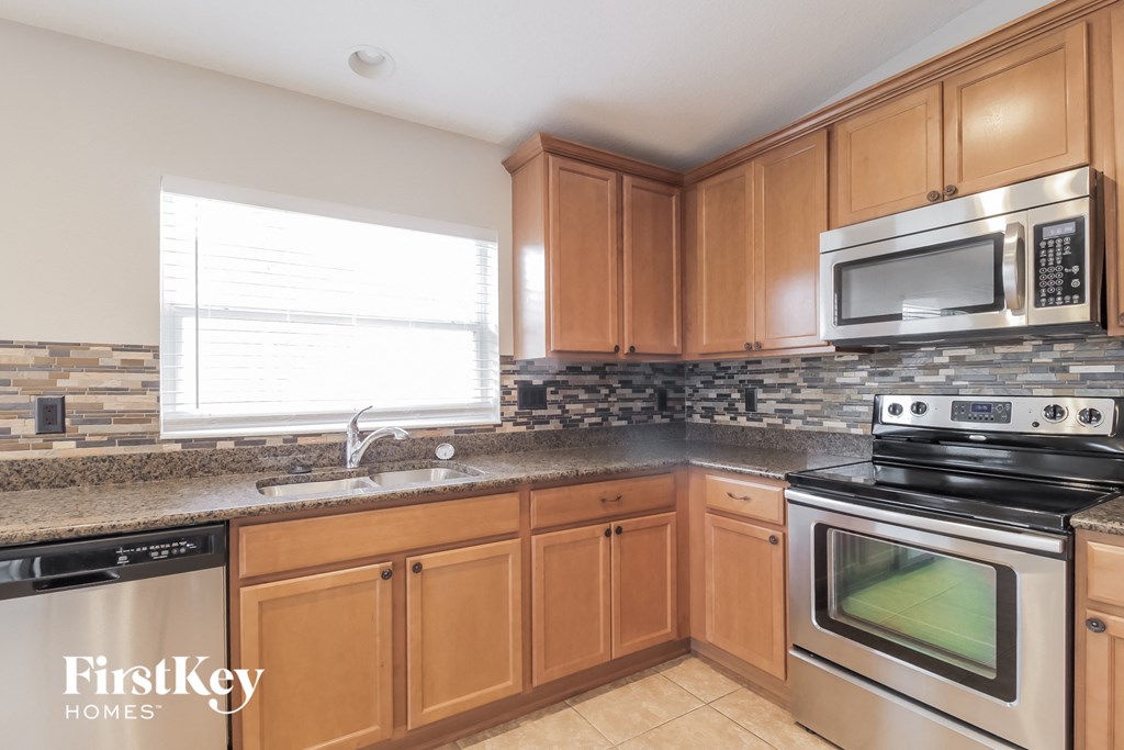 A kitchen with wooden cabinets and a stainless steel oven.