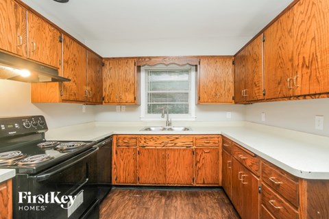 A kitchen with wooden cabinets and a black stove top.