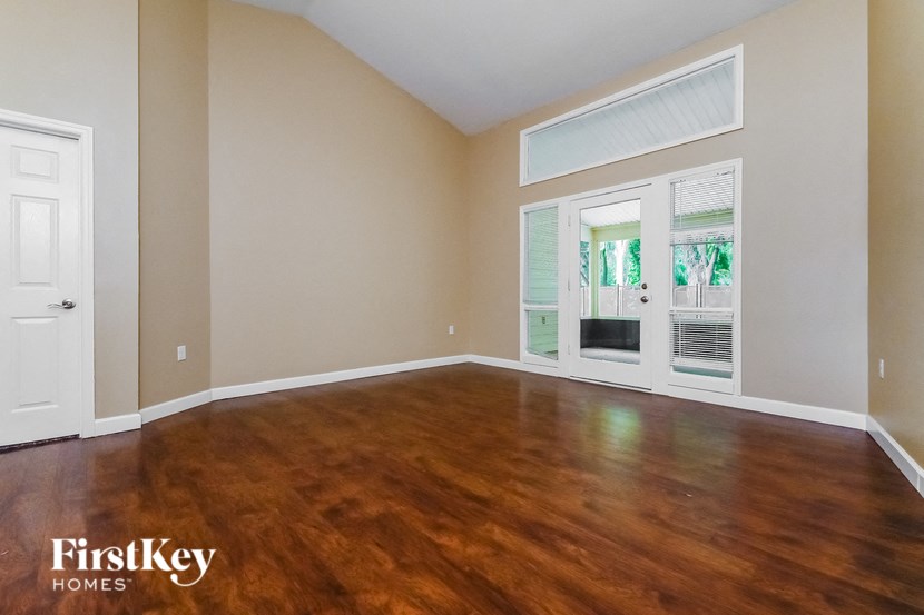 the living room of an empty house with wood flooring