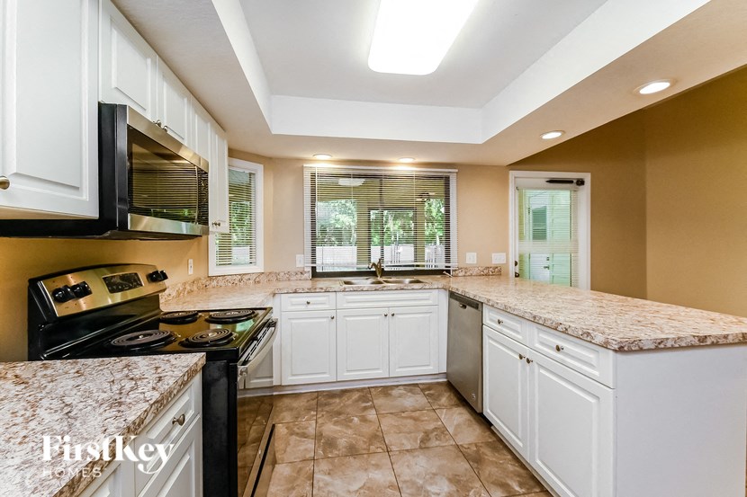 a kitchen with white cabinets and granite counter tops