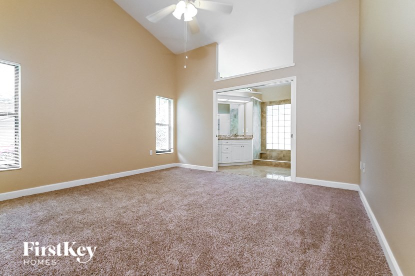 an empty living room with carpet and a bathroom