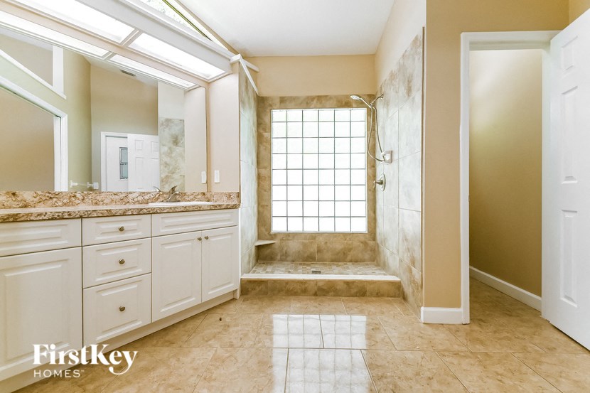 a bathroom with a shower and a sink and a mirror