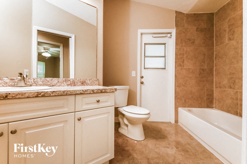 a bathroom with a toilet and a tub and a sink