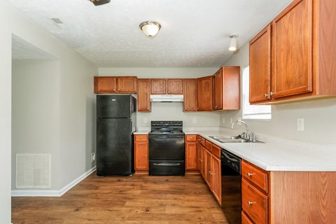 A kitchen with wooden cabinets and black appliances.