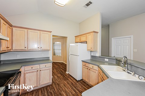 A kitchen with wooden cabinets and a white refrigerator.