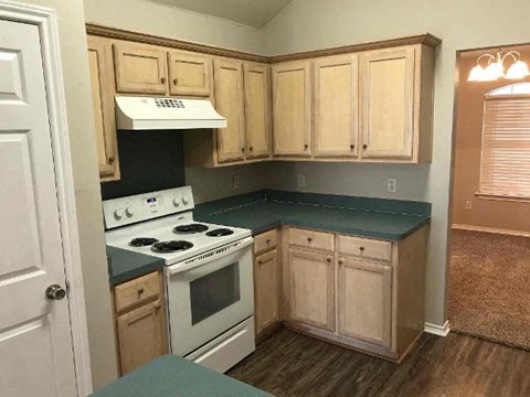 a kitchen with white appliances and wooden cabinets