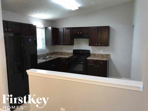 A kitchen with a black fridge and black oven.