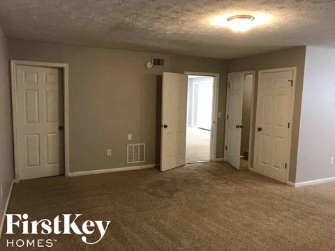 A room with a carpeted floor and a FirstKey Homes logo.