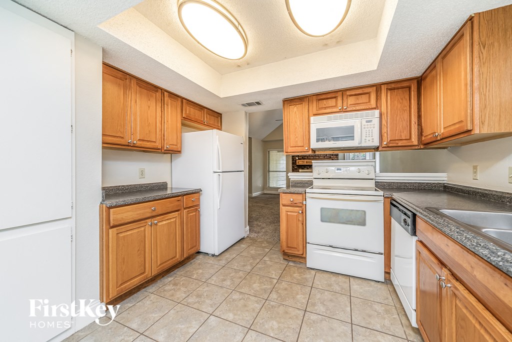 A kitchen with wooden cabinets and white appliances.