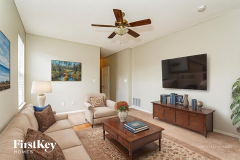 A living room with a couch, chair, and a painting on the wall.