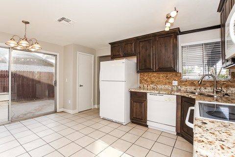A kitchen with white appliances and brown cabinets.