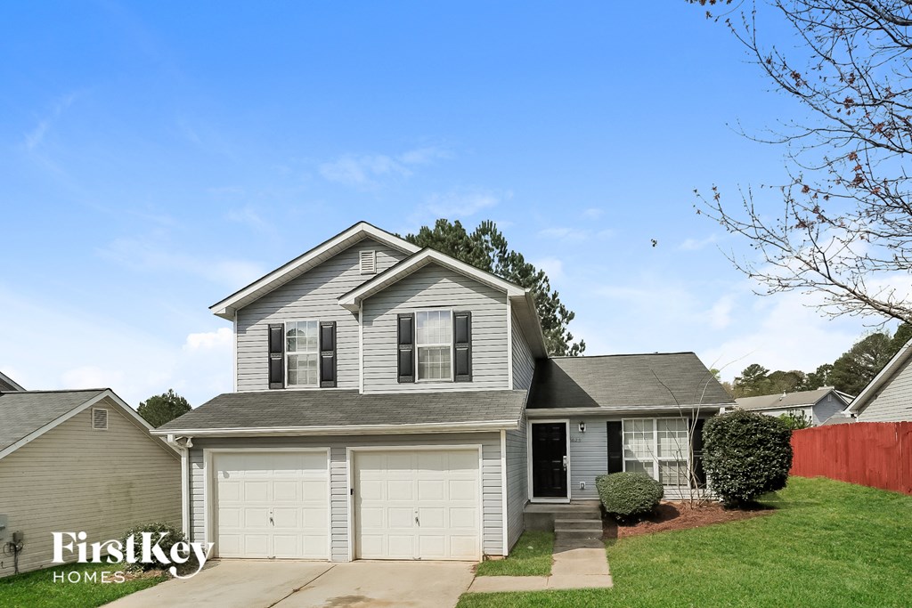 a house with two garage doors and a lawn