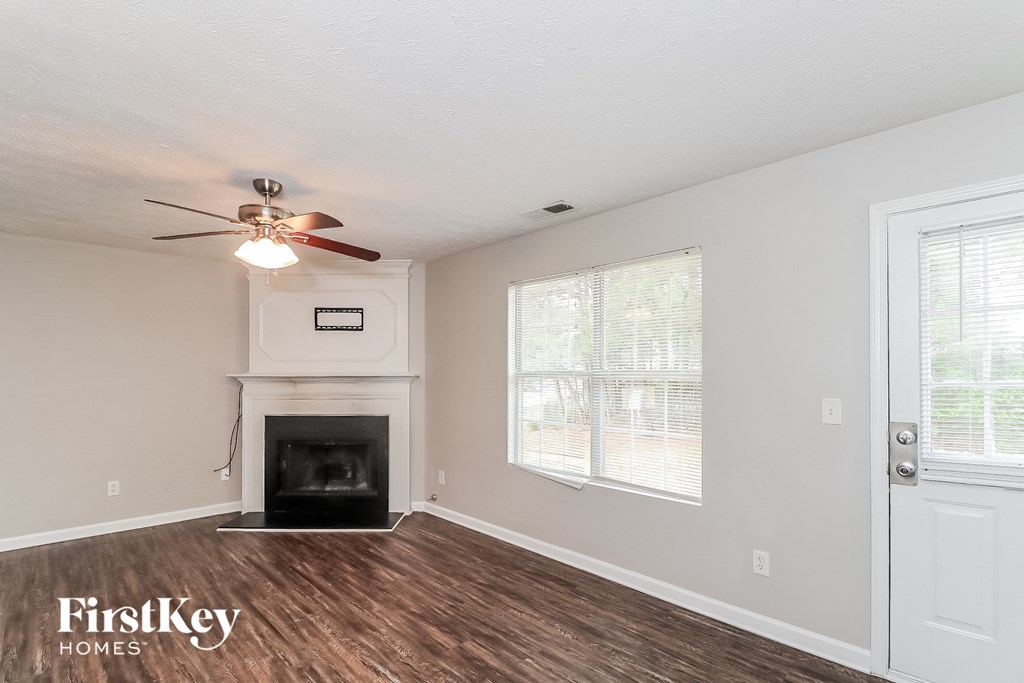 a living room with a fireplace and a ceiling fan