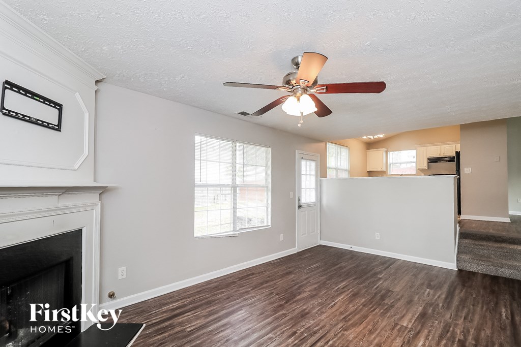 a living room with a ceiling fan and a fireplace