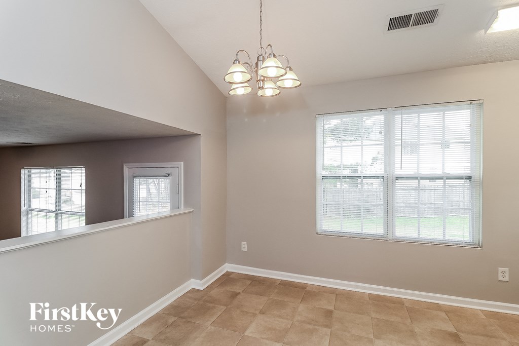 a living room with a large window and a ceiling fan