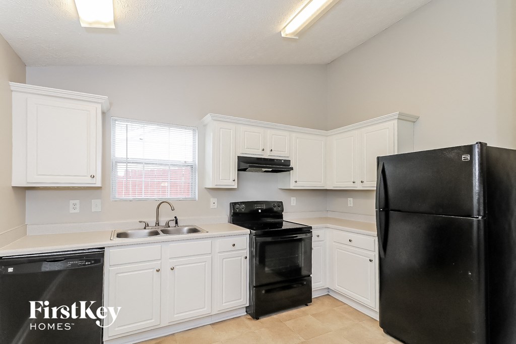 a kitchen with black appliances and white cabinets