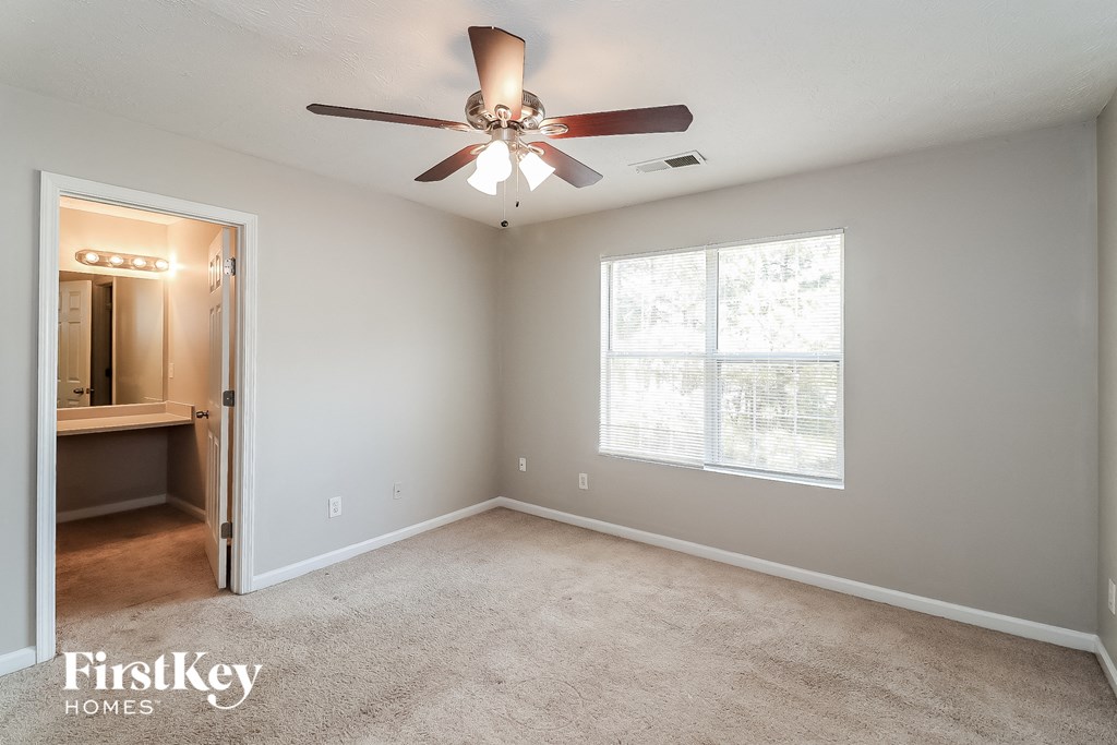 an empty room with a ceiling fan and a window