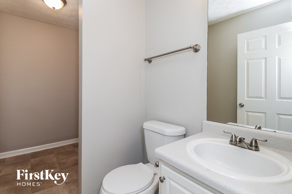 a bathroom with a sink toilet and a mirror