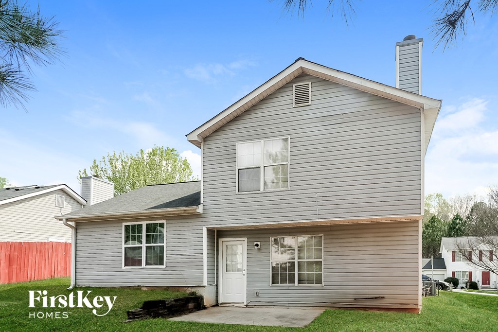 a white house with a red fence and a blue sky