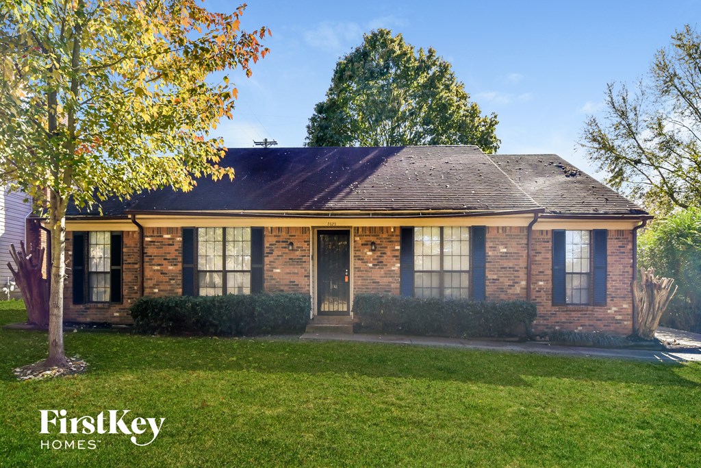 A brick house with a tree in front of it.